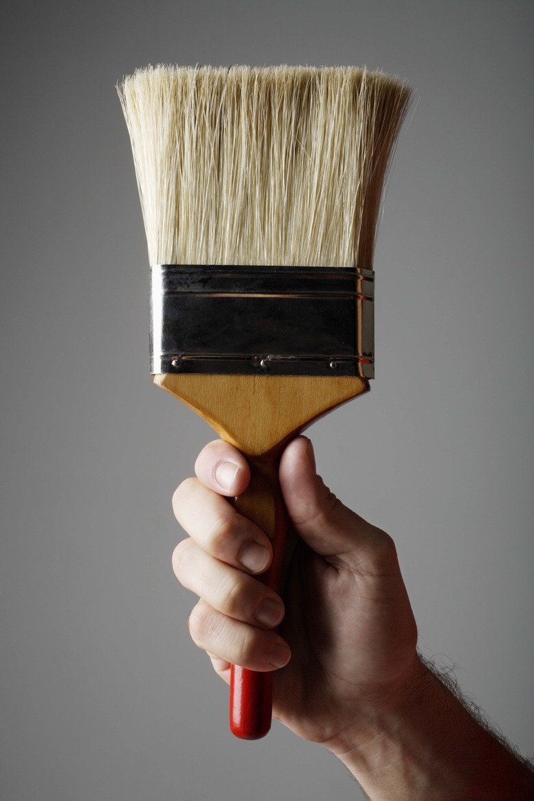 Hand holding paintbrush