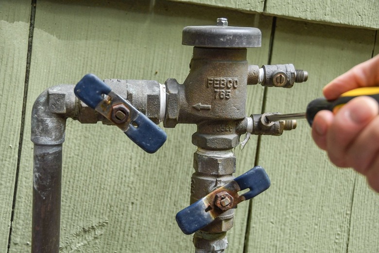 closing sprinkler system test valves at backflow preventer with screwdriver