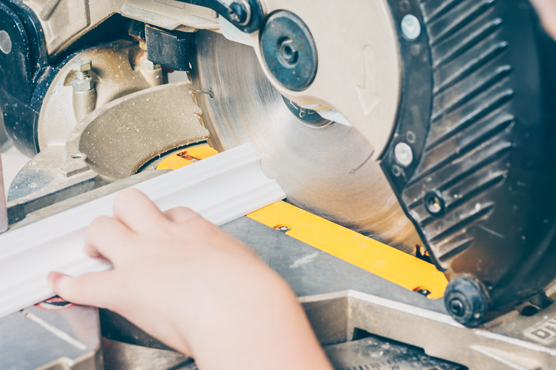 Miter saw cutting molding.
