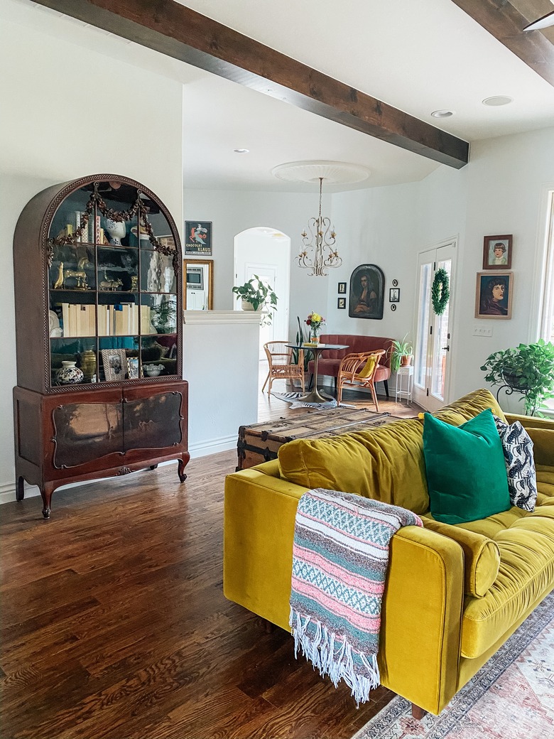 Sarisa Munoz The Indigo Leopard Home living room with mustard yellow velvet sofa and vintage cabinet