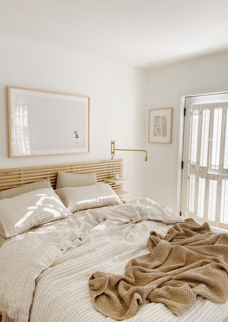 Sylvia Tribel bedroom with IKEA headboard and brass wall sconces