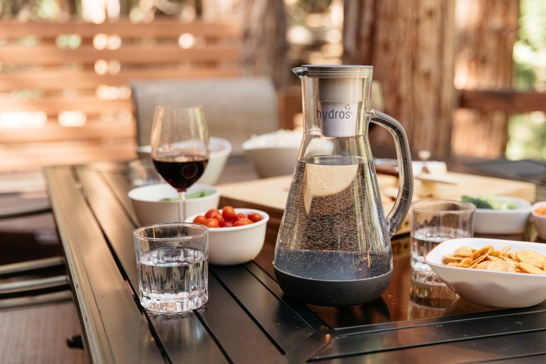 A Hydros water pitcher in gray rests on a black outdoor dining table