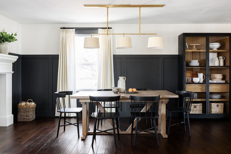 dining room with black wall paneling and white paint
