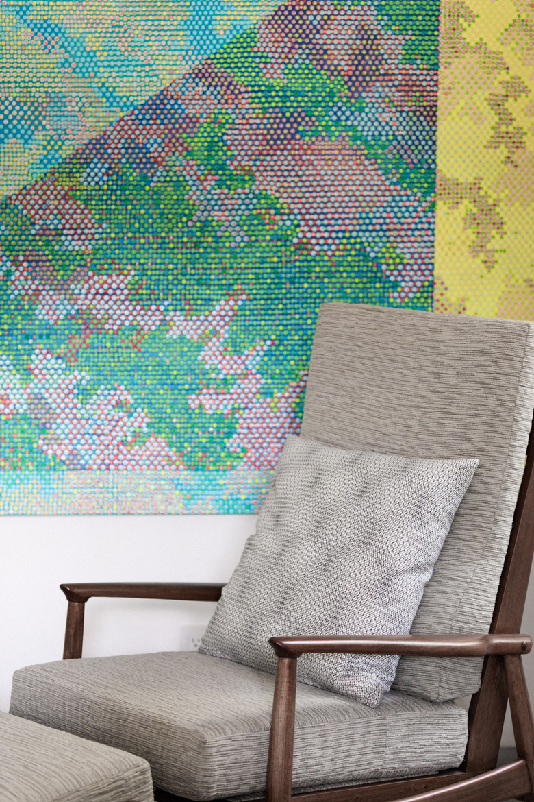 Gray chair in front of artwork