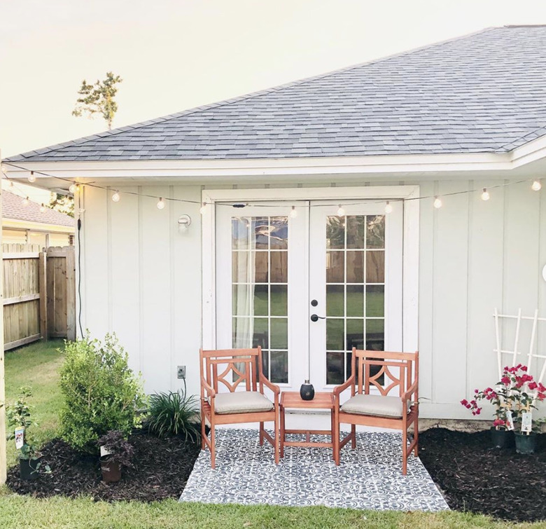 A small back patio before and after with a painted floor and red chairs