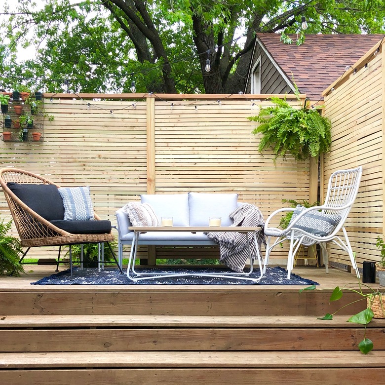 Back deck before and after with a slatted screen fence and wicker furniture
