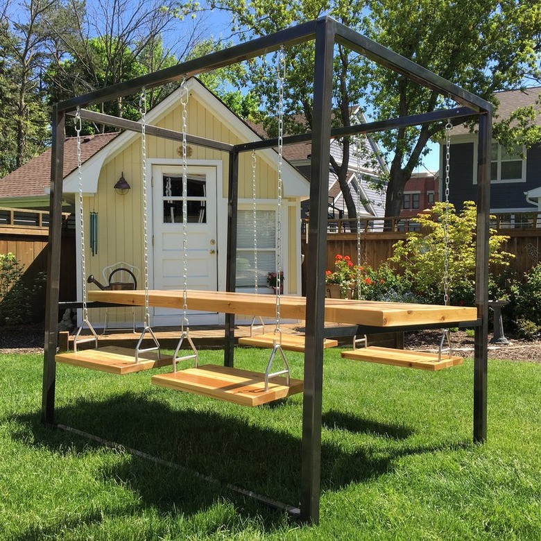 swing table and chairs on grass near a yellow house