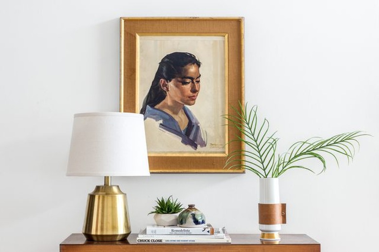 Leather handled vase sits atop a bedroom dresser