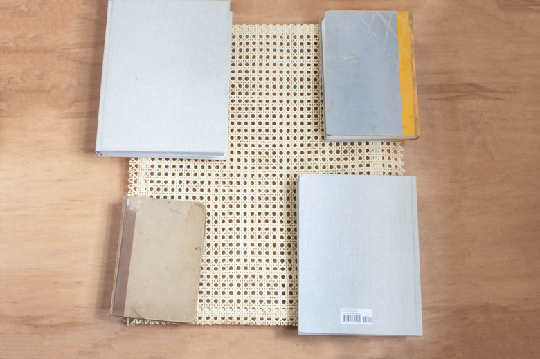 Weighing cane webbing down with books