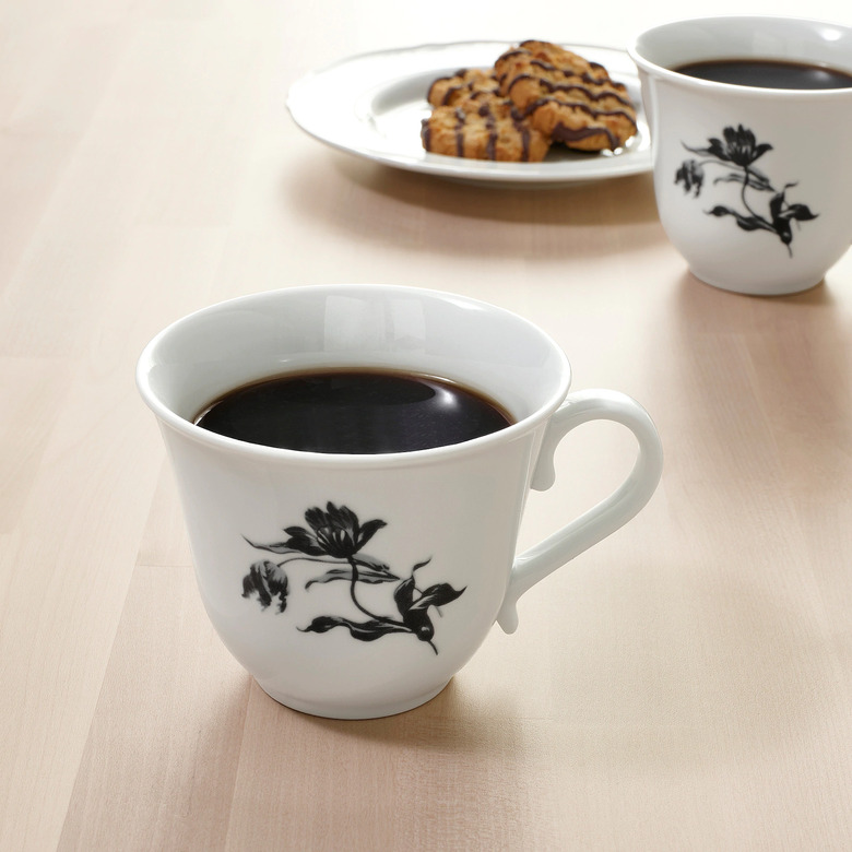 two mugs with plate of cookies in the background