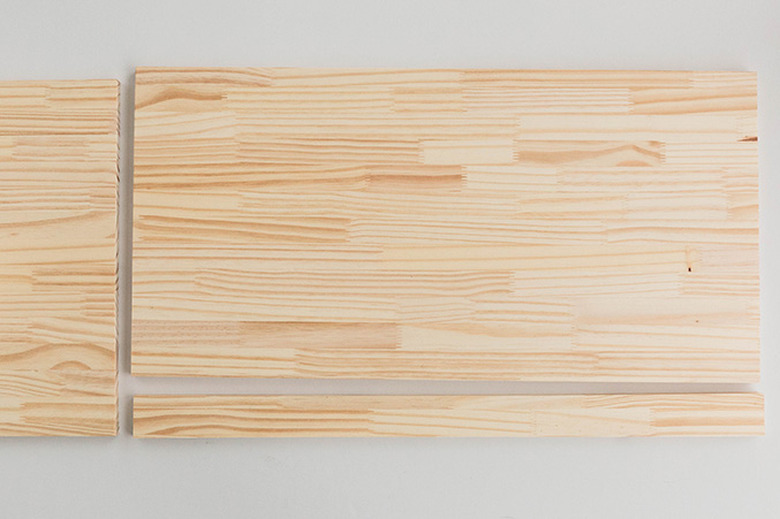 Cut the wood board to size so that it fits across the top of the cabinet.