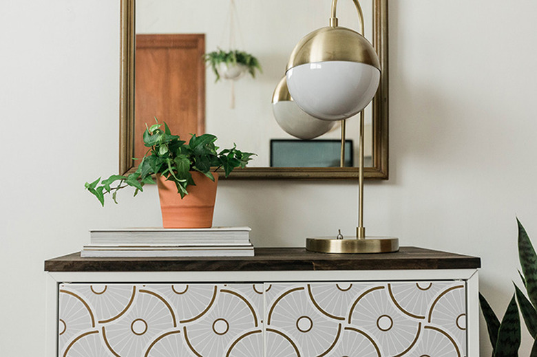 A vintage arched mirror adds more functionality when hung above an IKEA entry cabinet.