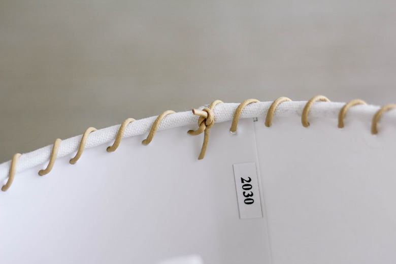 Ends of leather cord tied into knot inside lampshade