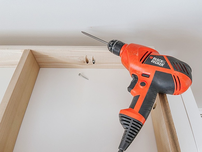 Screw the wooden base to the underside of the IKEA Kallax shelf.