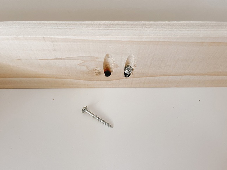 Detail of the screws going through the pocket holes into the bottom of the Kallax shelf.