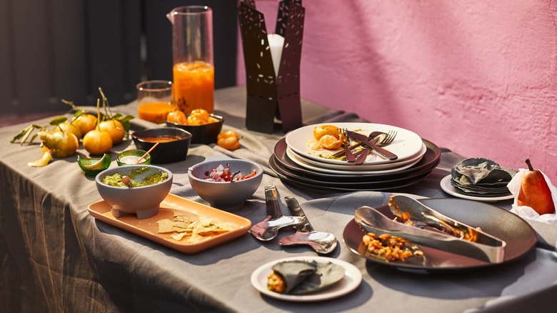 A table full of food and dishes from IKEA's ÖMSESIDIG collection. Guacamole