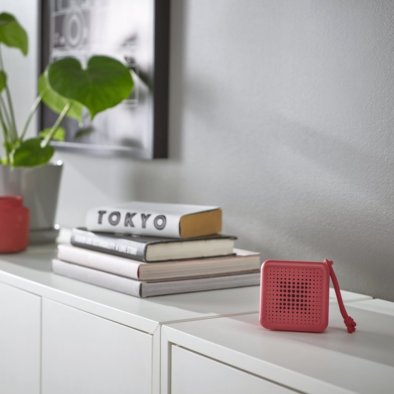 An IKEA VAPPEBY red speaker rests on a white console