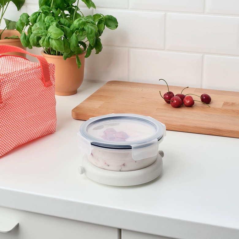 counter with container with ice pack and cutting board with cherries