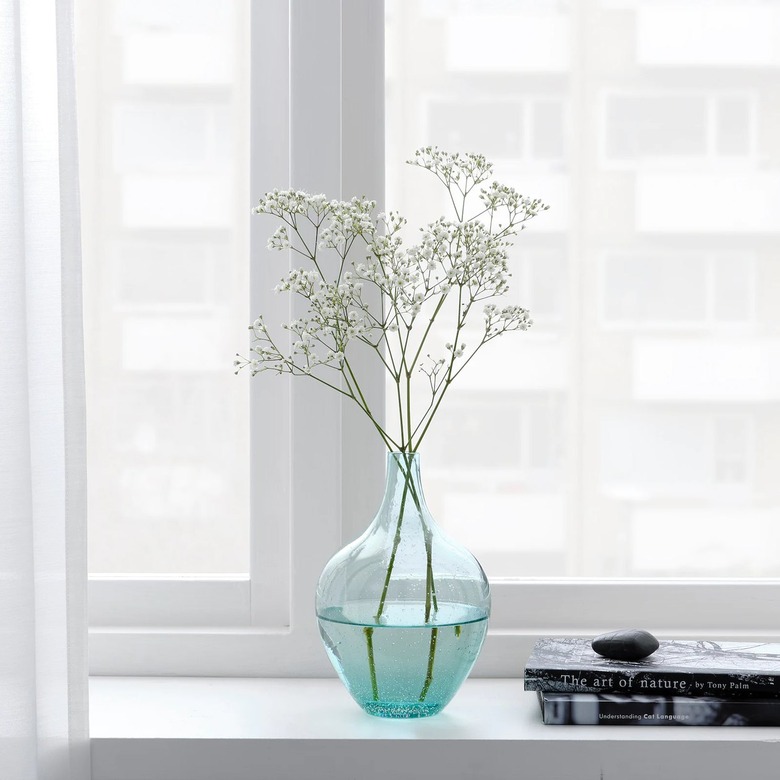 light turquoise vase with buds near white window