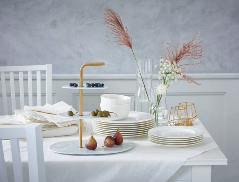table with white linens and plates and floral decor
