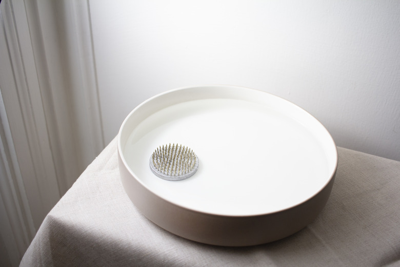 flower frog placed inside shallow bowl of water