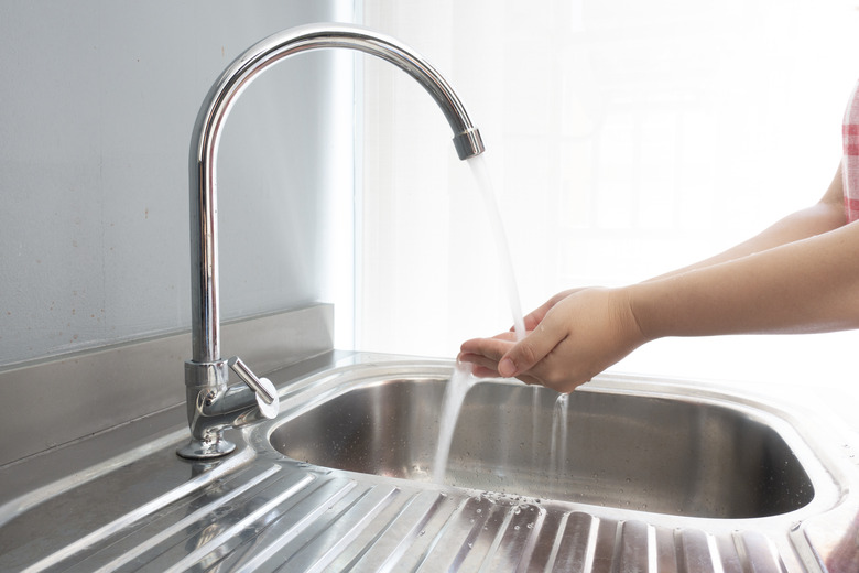 Washing hands at sink.