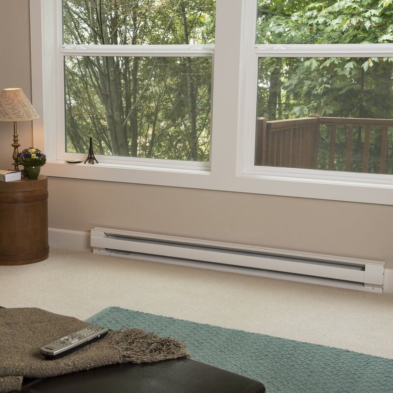 An electric baseboard heater on a carpeted floor