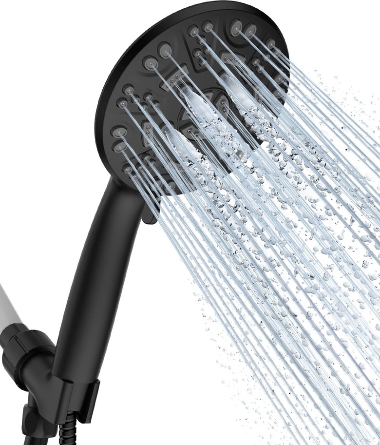 A black showerhead spraying water over a white background.