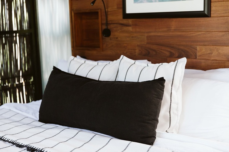 White and black bedding in wood paneled room