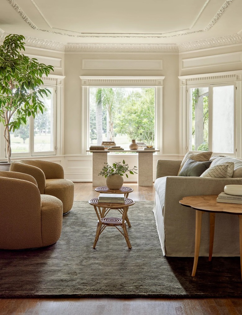 A moss viscose rug in a living room with a white couch and two light brown armchairs.