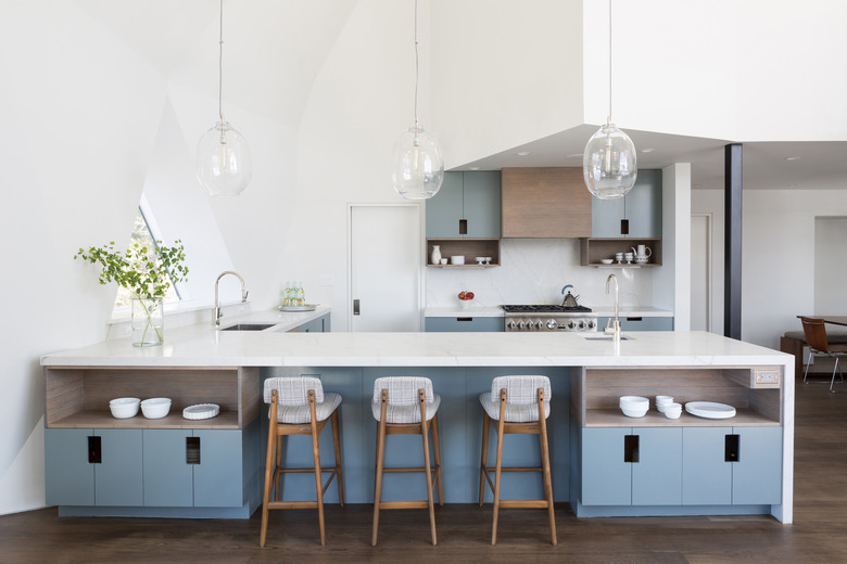 minimal kitchen with glass pendant lights and blue cabinets