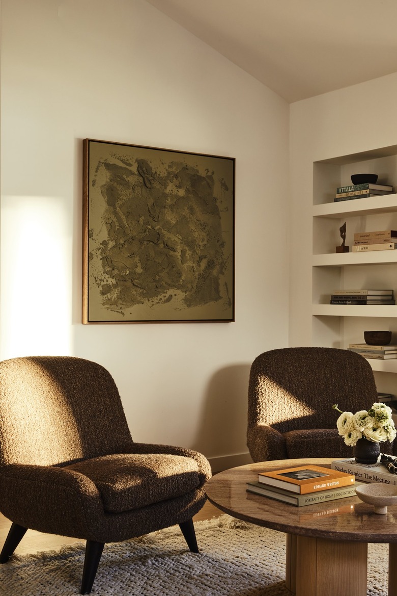 Cozy chairs sit at one and of the living room