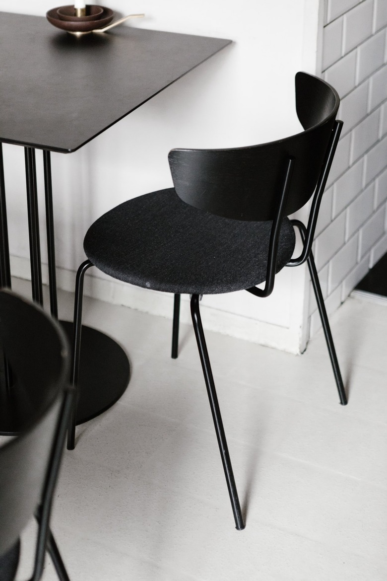 Black chair and table against white tiled wall