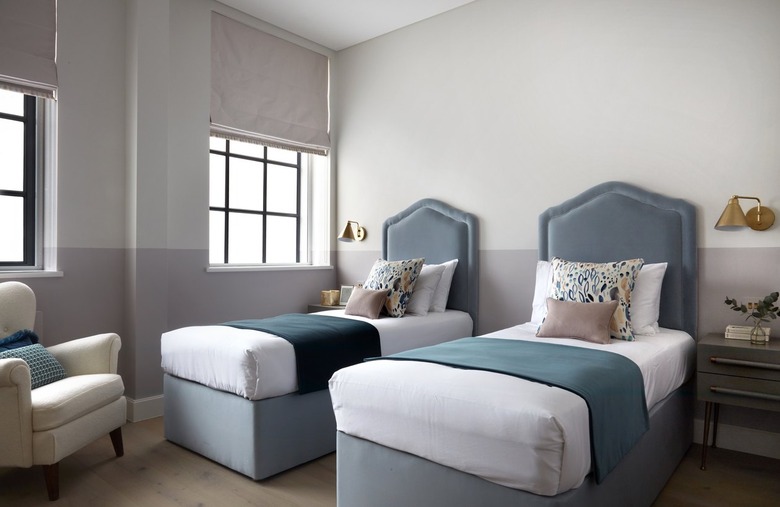 kids room with two beds with blue headboards