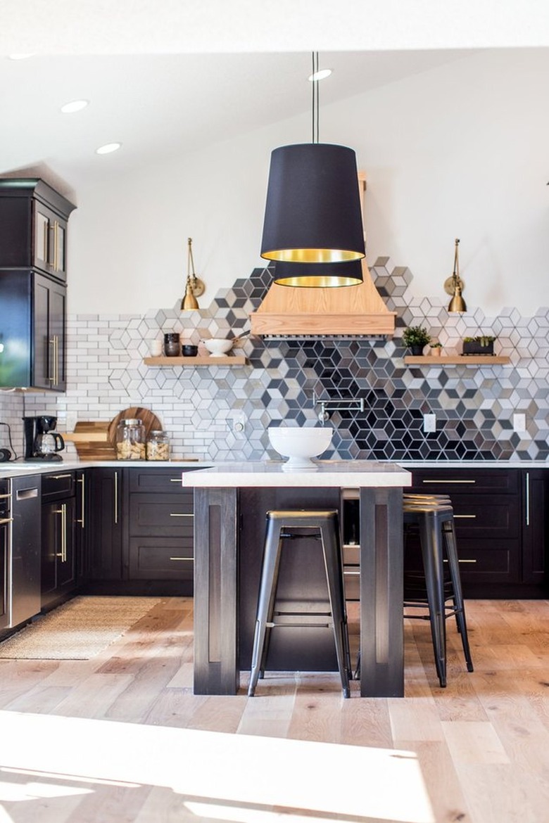 Black kitchen cabinets and island with large black pendants