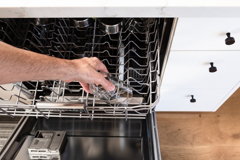 hand reaching for glass in dishwasher