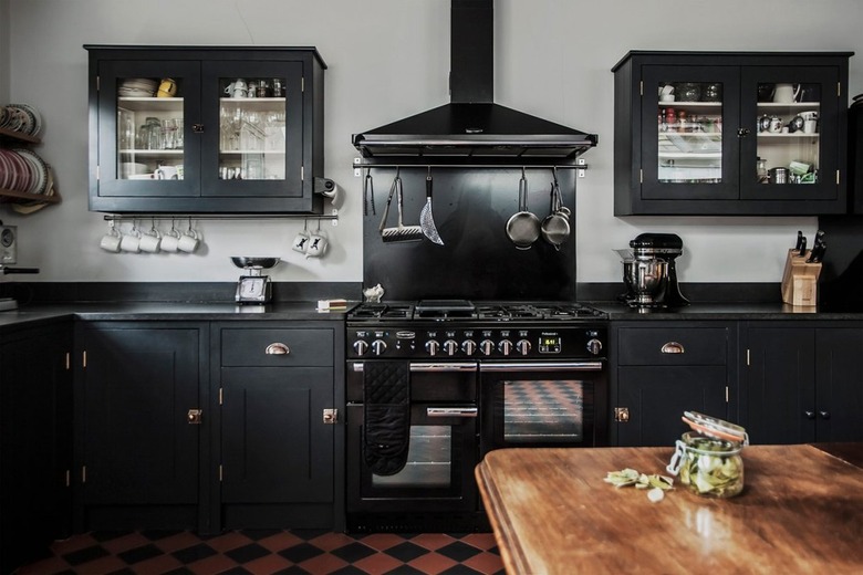 black kitchen cabinets with black appliances gray walls