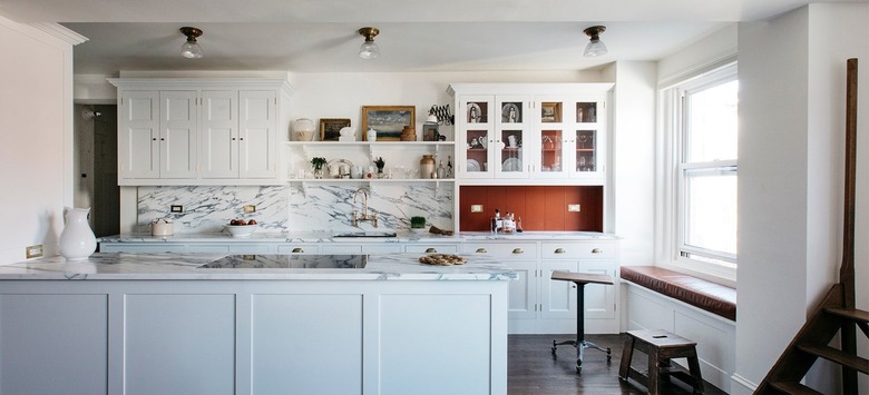 white kitchen cabinets with burnt orange accents and marble backsplash