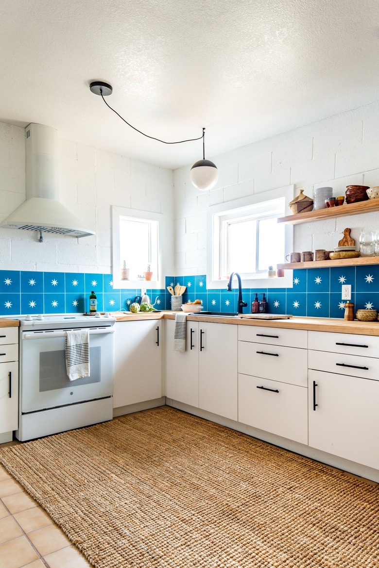 a kitchen with white cabinets and walls