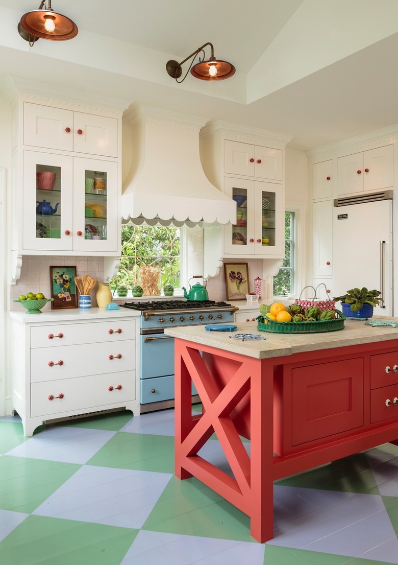 Colorful beach cottage kitchen with creamy white cabinetry and coral island