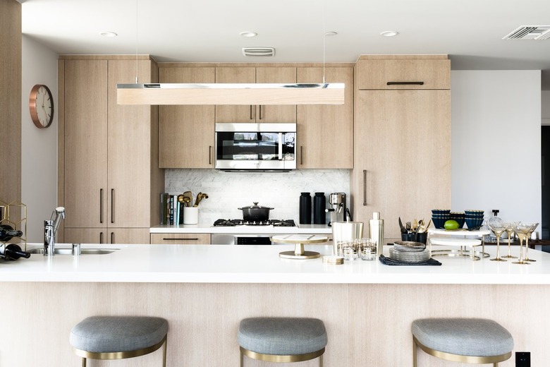Light wood cabinet kitchen with a bar pendant light