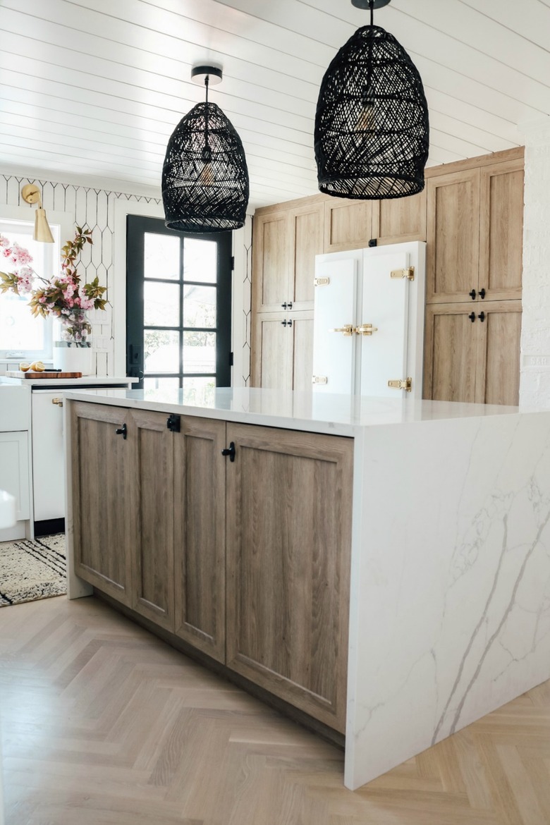 black rattan lights above marble island in wood kitchen
