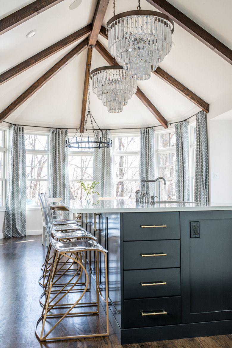 crystal chandeliers hanging above traditional black kitchen island