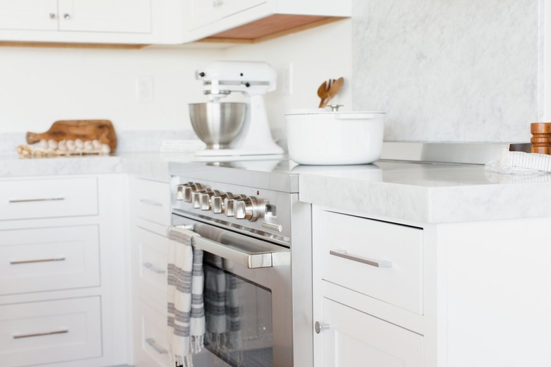 Kitchen counter with white drawers and a white marble countertop. In the middle of the counter