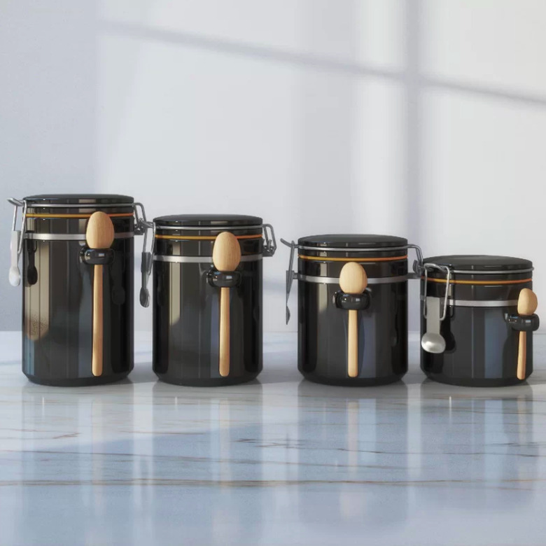 Four black kitchen canisters in varying sizes
