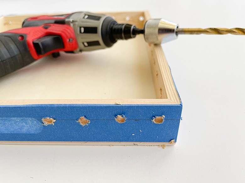 Drill holes through the painter's tape and rim of the tray.