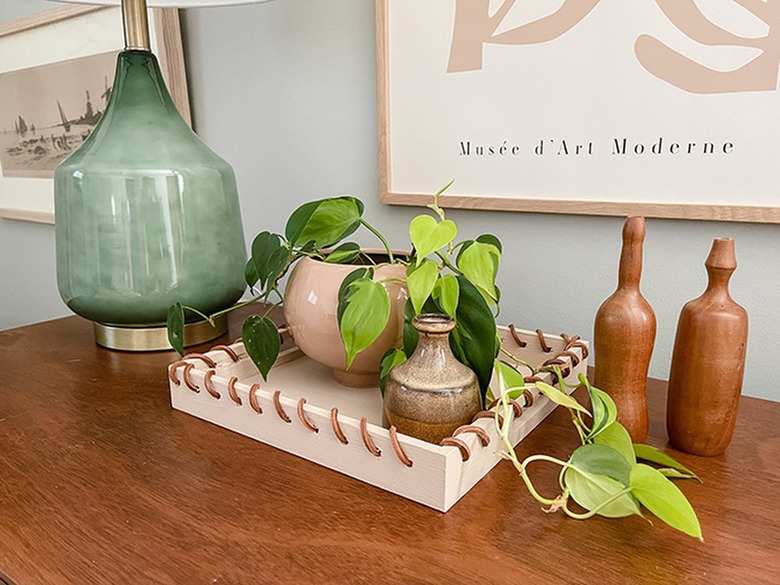 Let the paint dry and then wrap leather cording through the holes.