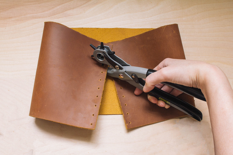Punching holes on dots marked on leather with leather punch tool