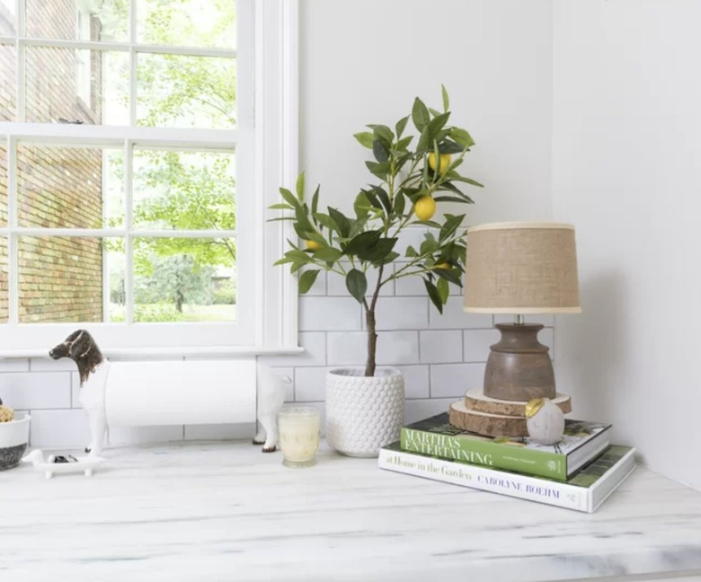 Image of faux lemon tree on a table accessorized with books