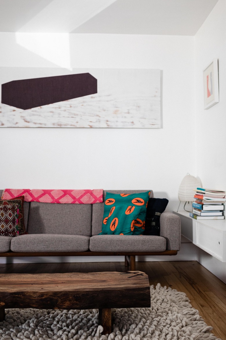 Grey sofa with artwork on wall and wood coffee table